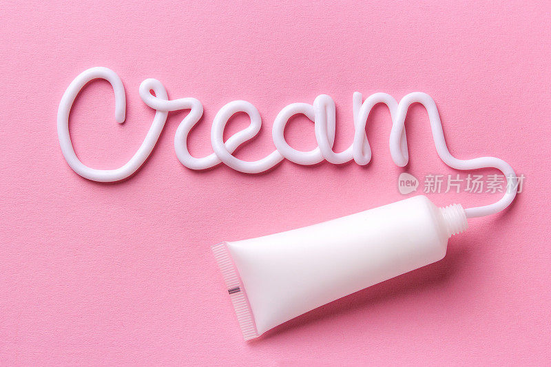 这个词是用一种奶油写在粉红色的背景上。模型白色管奶油