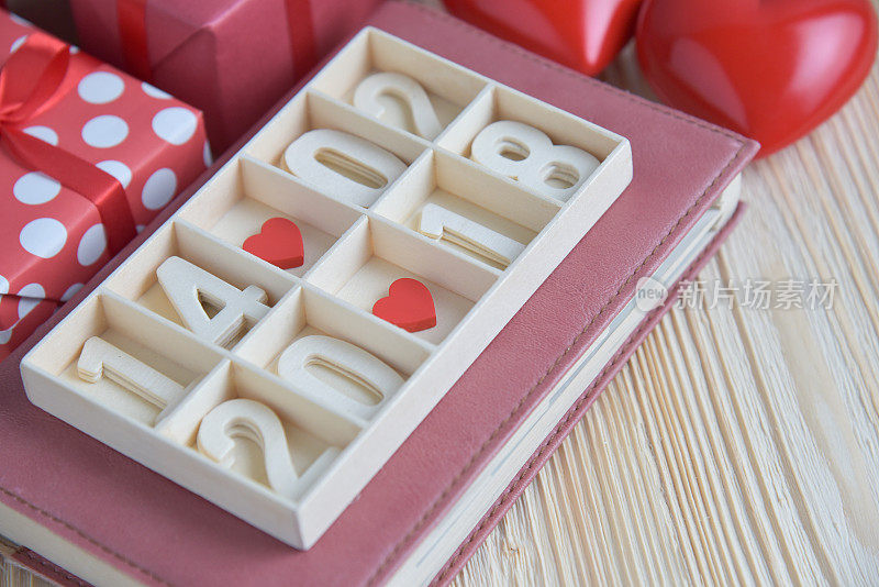 木块日历显示日期，月和年，两颗红心和礼盒。
