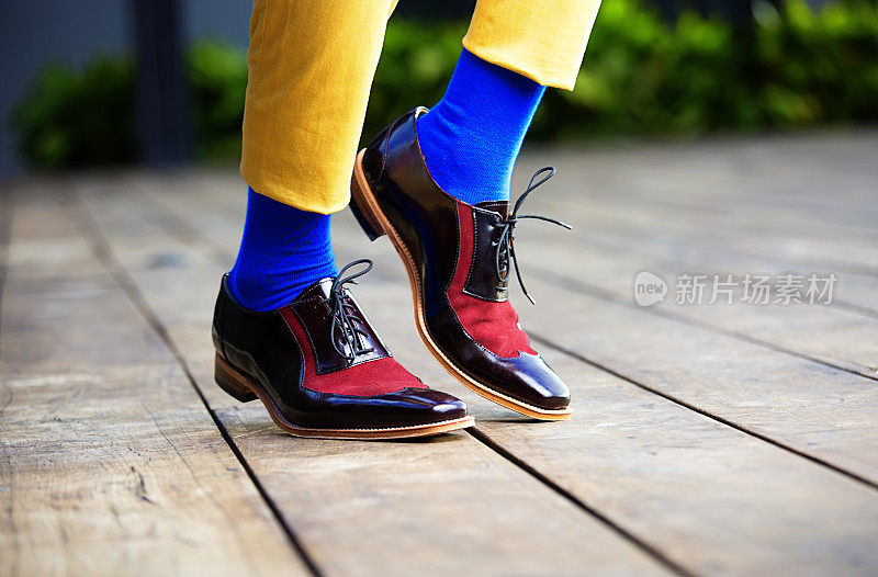 穿着蓝色袜子和红色绒面革鞋的时髦男人