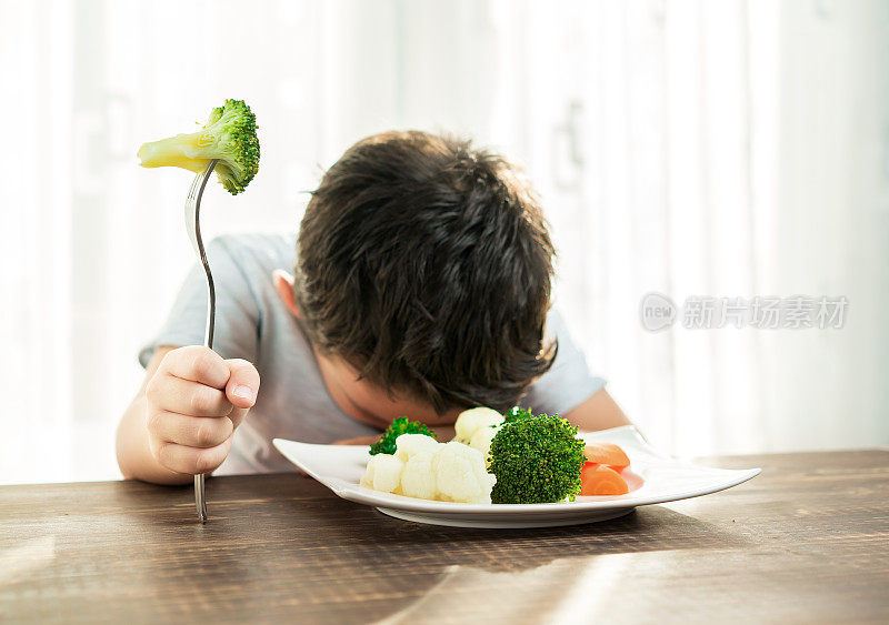 孩子对不得不吃蔬菜很不高兴。
