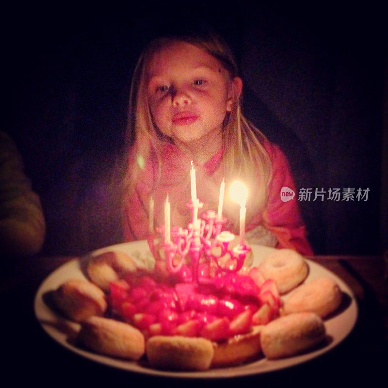 生日女孩吹灭她生日蛋糕上的五根蜡烛