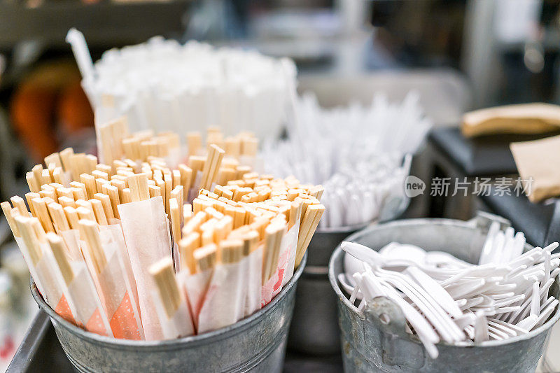 许多一次性木制筷子在纸包装的碗在亚洲日本餐馆快餐休闲咖啡馆由塑料餐具，叉子，勺子