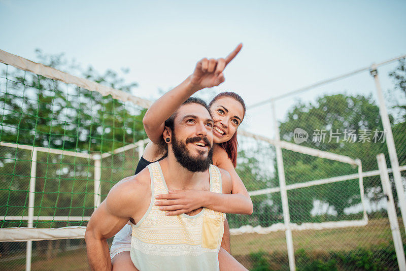 一对幸福的情侣站在排球网前