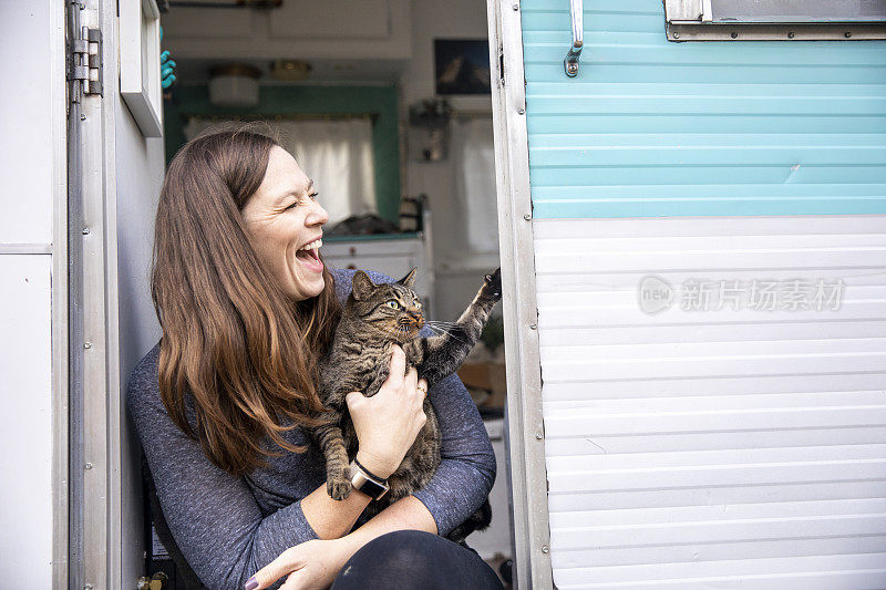 一个女人和她的猫在拖车里露营