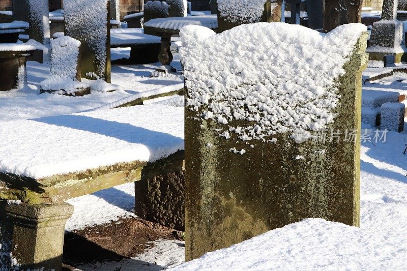 白雪覆盖的墓地里的坟墓、墓碑和墓碑