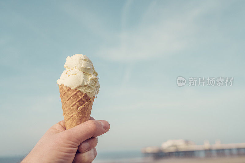 在布莱克浦海滨，手里拿着一个冰淇淋蛋筒。