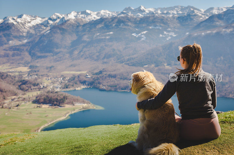 一位女士和她的狗欣赏景色