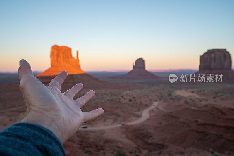 手伸向日落在纪念碑谷在美国，旅游概念