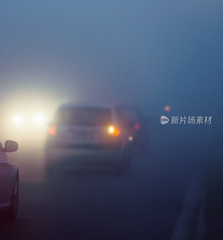 在浓雾中开着大灯的汽车
