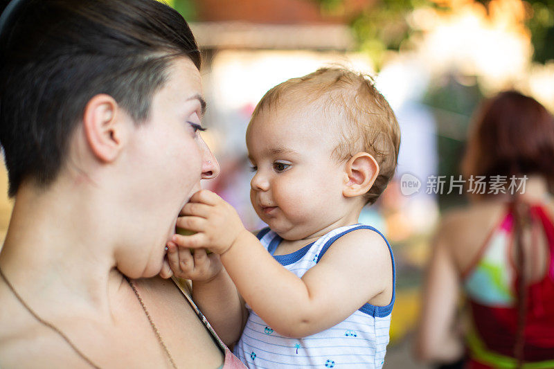 蹒跚学步的男孩给妈妈喂苹果