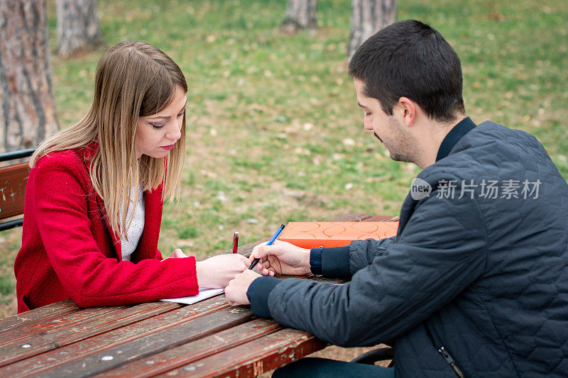 两个年轻人在公园里一起学习。