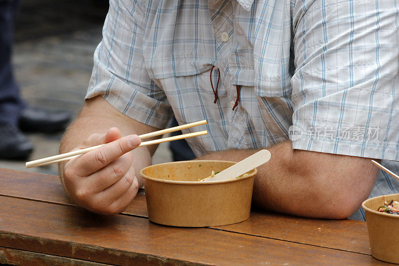 一名男子用筷子吃日本街头小吃