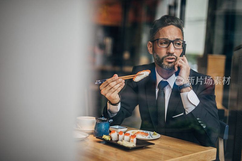 在寿司店打电话的男人