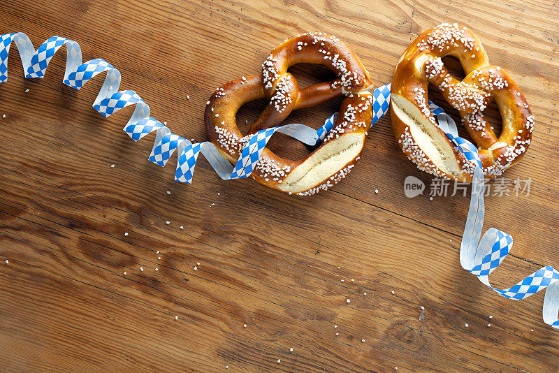 椒盐卷饼与丝带在木制桌子上-啤酒节背景