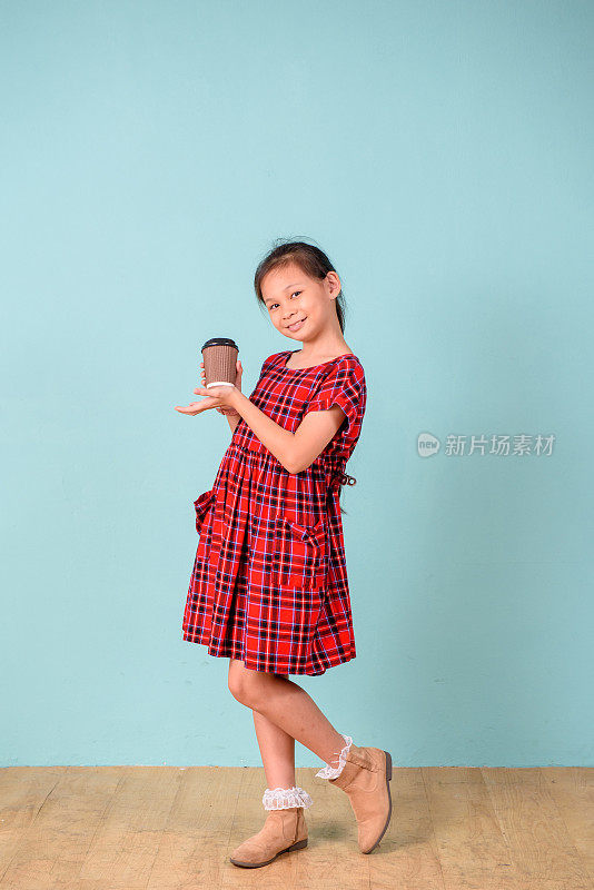 年轻的亚洲女孩拿着纸杯咖啡