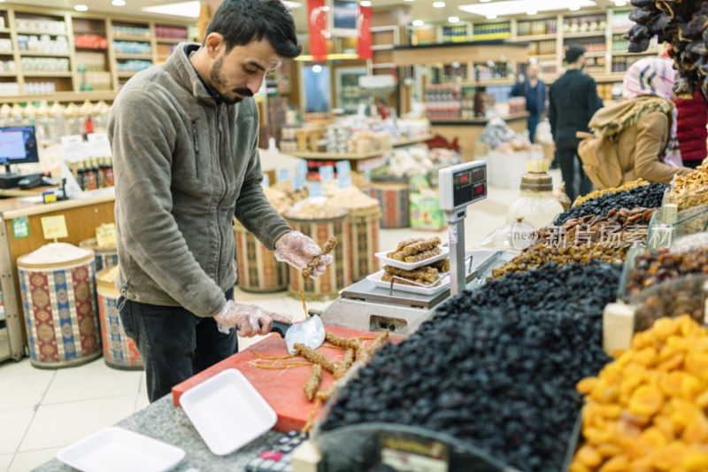 售货员在杂货店里切菜称重