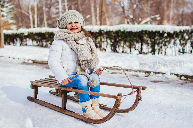 美丽的女孩在冬季公园滑雪