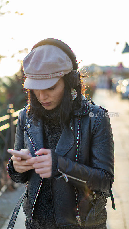 一个女人在街上用手机听音乐