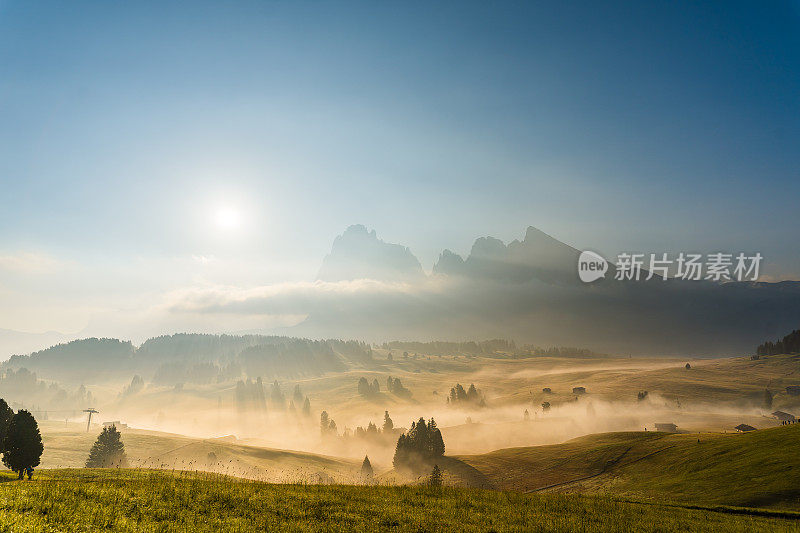 意大利Dolomites乡村景观，田野，树木，日出时起伏的山丘和山脉