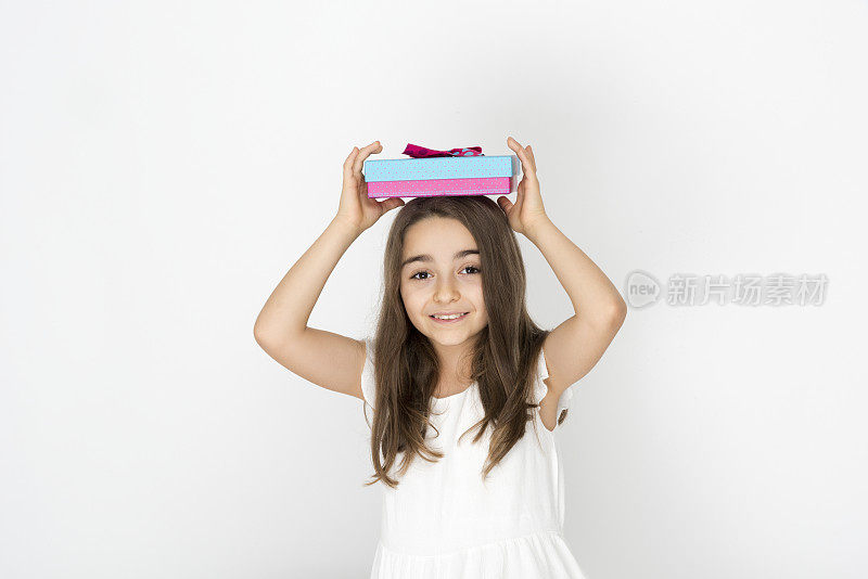 一个白种女孩把礼盒举过头顶表示快乐。