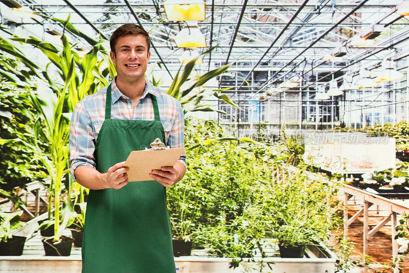 白人男性植物学家园艺穿着围裙和拿着剪贴板