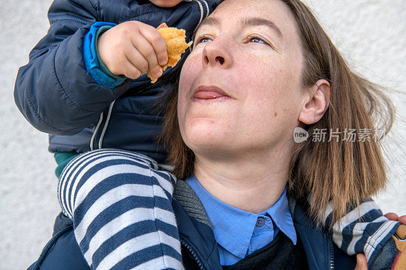 一个千禧年母亲骑在儿子肩上的肖像