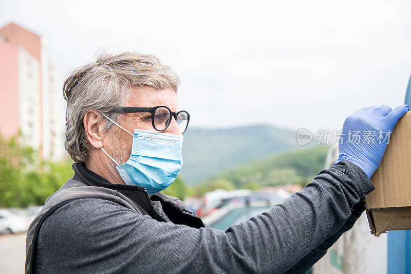 欧洲冠状病毒时代，戴口罩的老人对垃圾进行分类