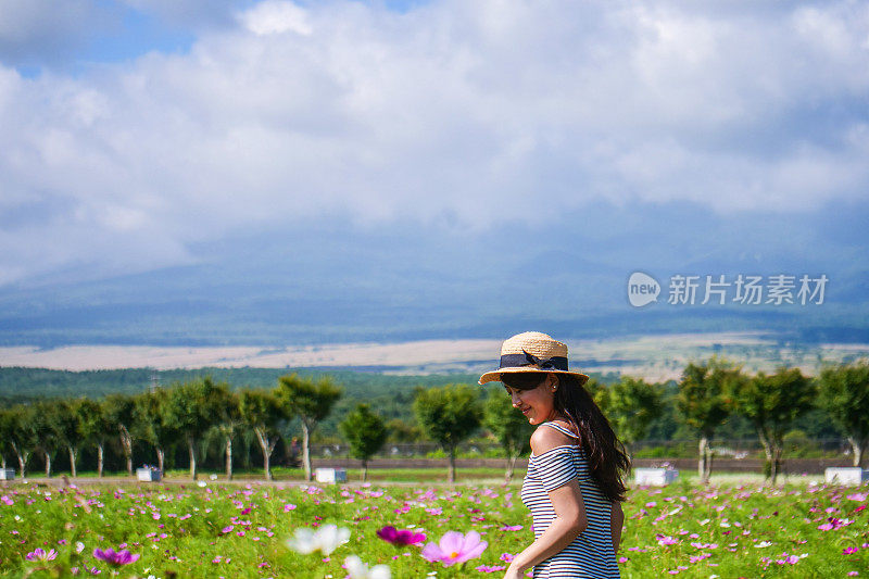 美丽的年轻女子在花圃休息