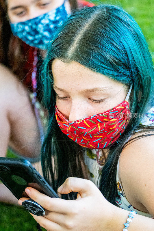 白人女孩使用保护面罩看智能手机