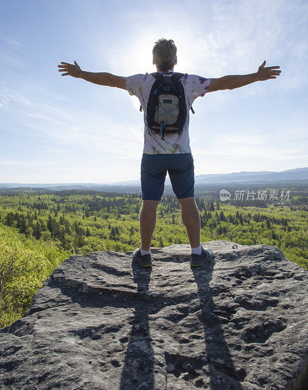 徒步旅行者在山脊上伸开双臂放松