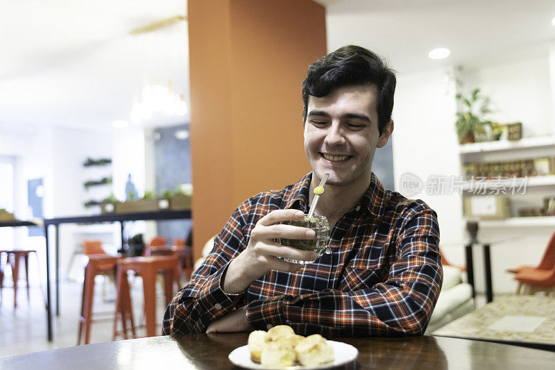 一个年轻男子在酒吧喝酒的照片