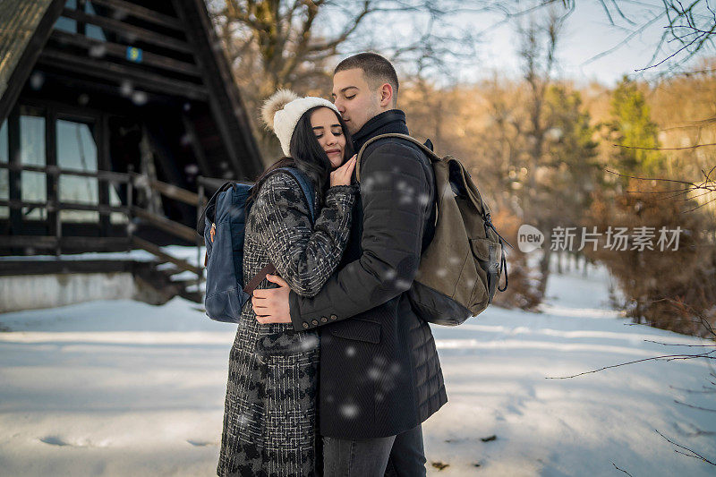 这对快乐的情侣在雪山徒步旅行时微笑着用手机自拍