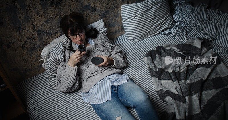 一个女人躺在沙发上喝着咖啡