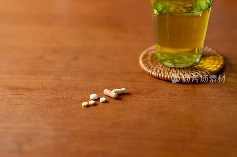 多种药物，包括药丸和胶囊，都在家里的桌子上。