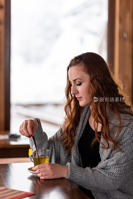 漂亮的年轻女人在咖啡馆喝茶存货照片