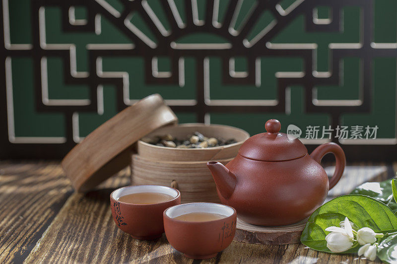 窗花旁桌上的中国茶壶和茶杯富有禅意