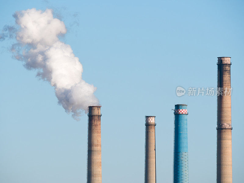 浓重的烟和蒸汽从工业烟囱里冒出来。环境污染的概念。