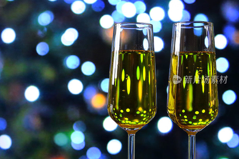 特写图像的香槟长笛包含起泡酒，干杯，葡萄酒杯庆祝祝酒词，照明仙光散景背景，聚焦前景