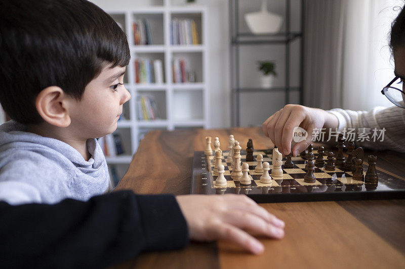 弟弟在家里一起下棋。家人在家里。