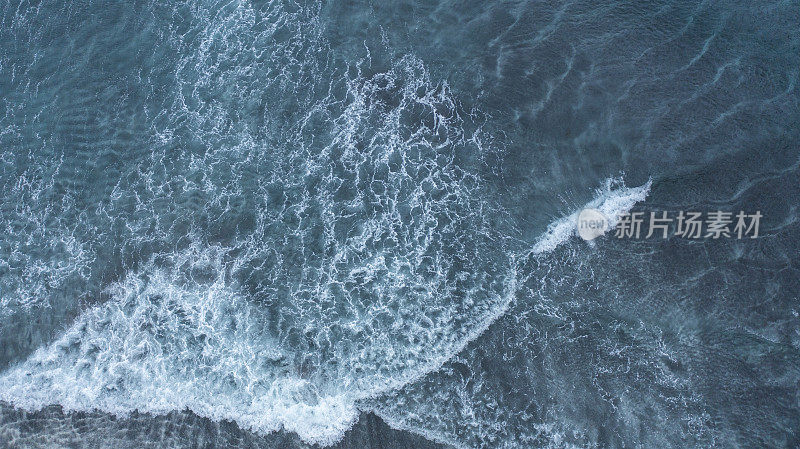 从高处俯瞰巨浪拍打海岸的景象。