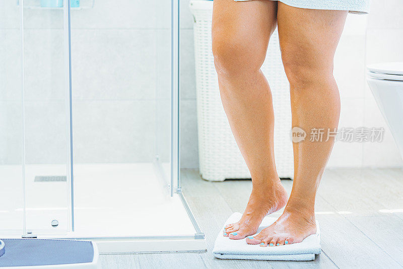浴室里站在体重秤上的女人