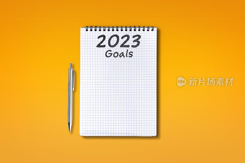 2023目标字母在方格笔记本，孤立的橙色背景