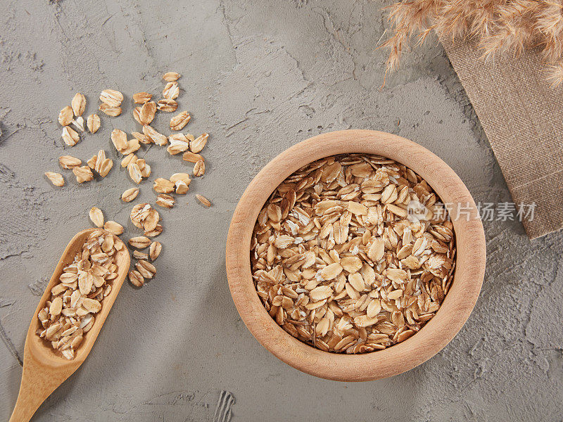 燕麦片在碗与勺子在木头背景