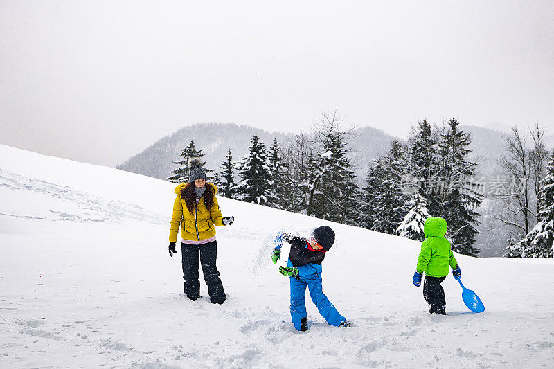 一家人带着两个孩子在雪地里享受美好的一天