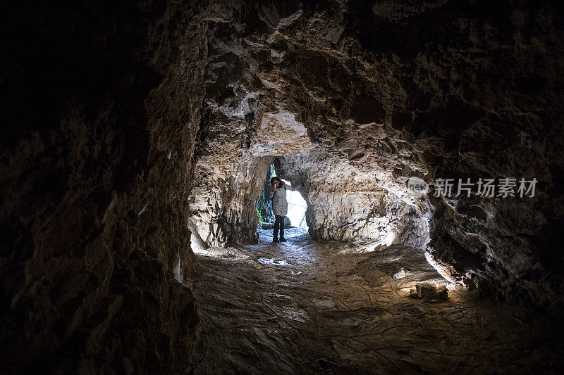 一名成年女子正在探索洞穴