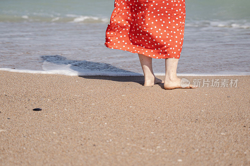 人在自然中。怀孕的妈妈光着脚在海边。