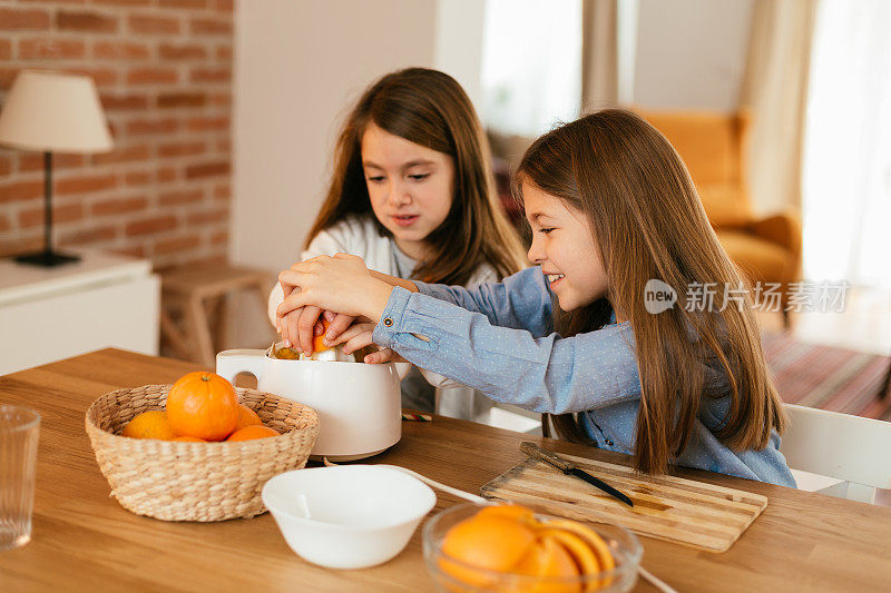 孩子们在家里快乐地挤橙子和做橙汁