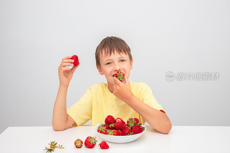 孩子手里拿着草莓，吃草莓是健康营养的概念。夏天收获