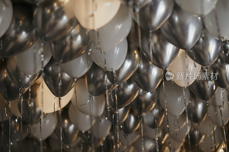 白色和灰色闪闪发光的派对气球，情人节房间装饰，银色氦气球，新娘房间装饰，氦气球。库存图片