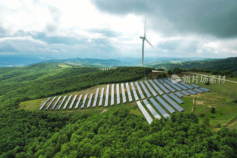 森林地区的太阳能电池板和风力涡轮机。可再生能源